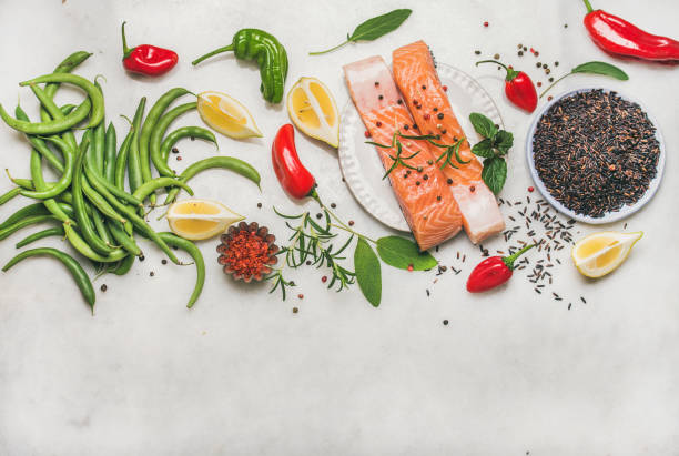 Flat-lay of raw salmon fish fillet steaks with vegetables, greens