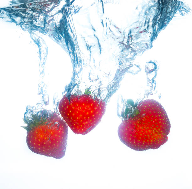 strawberries falling into water and splashing - wet strawberry macro fruit imagens e fotografias de stock