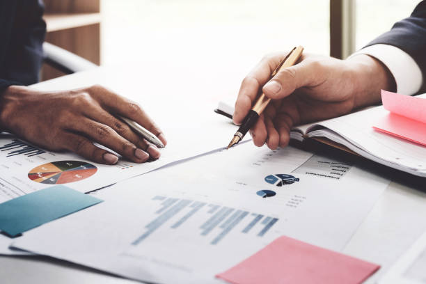 istock Close-up of business man and partner hands pointing at business document while discussing it 864104436