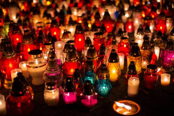 istock Burning colourful candles on cemetery at night. 864104524