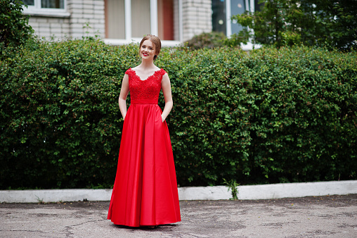 Portrait of a beautiful and gentle girl in elegant gown posing outdoor.