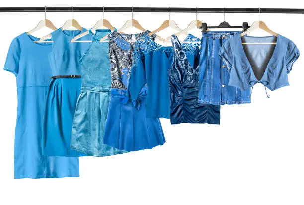 Set of blue woman clothes on clothes racks on white background