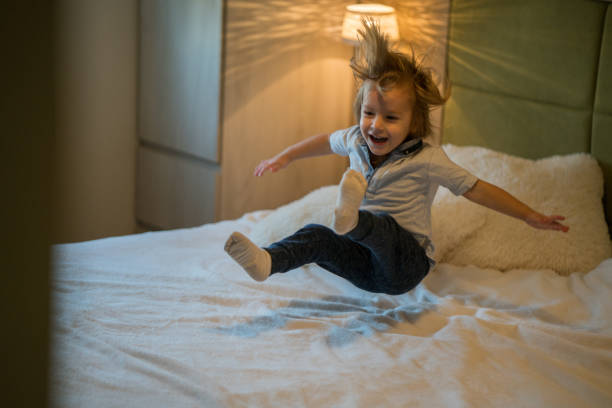 istock Happy boy jumping on the bed 864113678