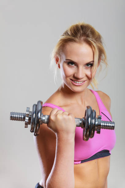 istock Fit woman lifting dumbbells weights 864114082