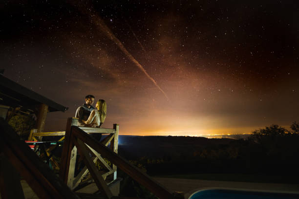 istock Young couple enjoying in romantic moments under starry sky. 864137908
