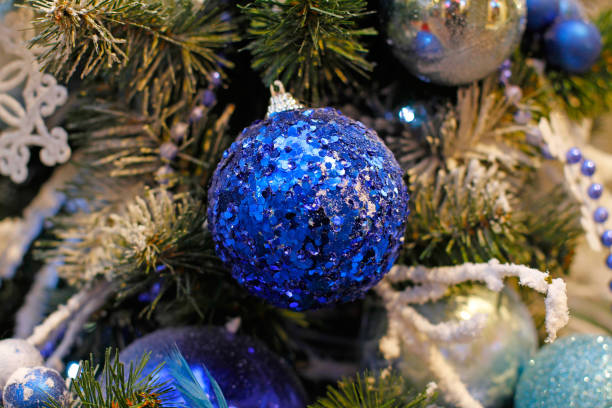 istock Blue ball hanging on a branch 864145662