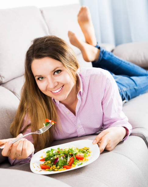 istock Girl eating green salad 864146106