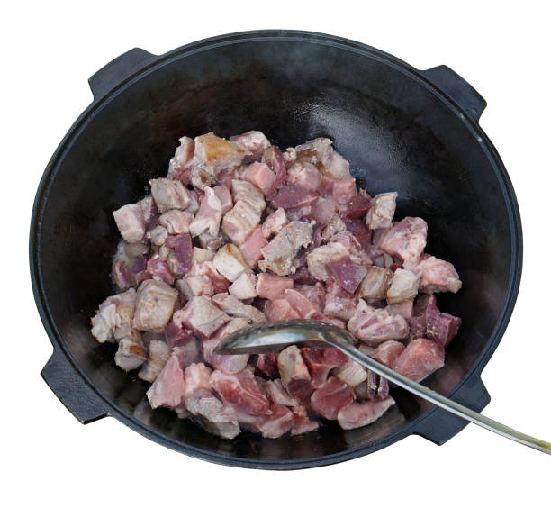 istock Stirring of meat during roasting in a iron  pan at the stake. 864149546