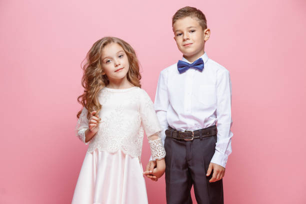 istock Boy and girl standing in studio on pink background 864154496