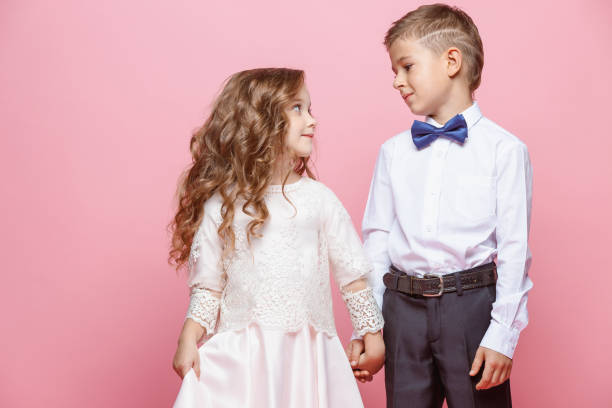 istock Boy and girl standing in studio on pink background 864154616