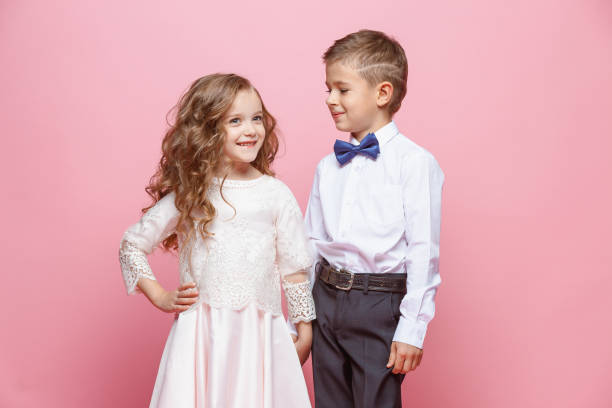istock Boy and girl standing in studio on pink background 864154724
