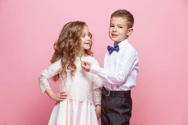 istock Boy and girl standing in studio on pink background 864154852