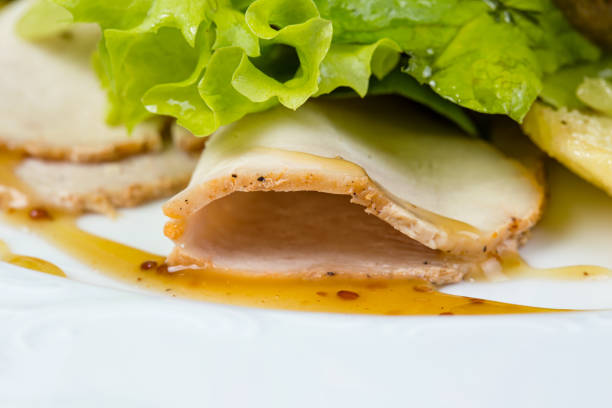 Slices of hamilton and green salad on white background