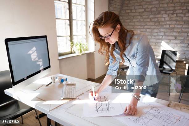 Female Designer In Office Working On Architects Project Stock Photo - Download Image Now