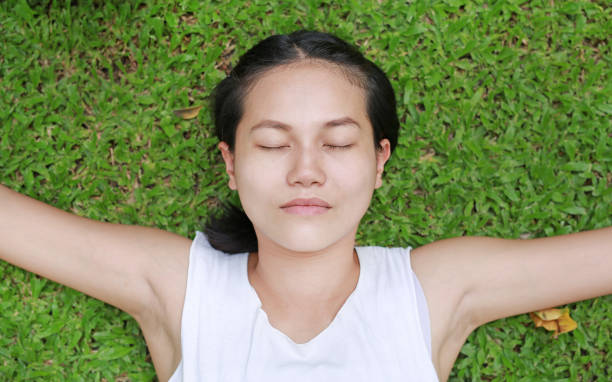 istock Close up asian female lying on green grass. 864180100