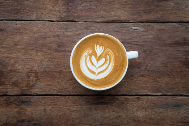 una tazza bianca di caffè caldo latte art sul tavolo di legno in caffetteria - morning coffee coffee cup two objects foto e immagini stock