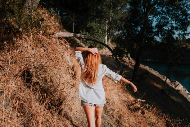 istock Woman walking along narrow path in nature. 864181820