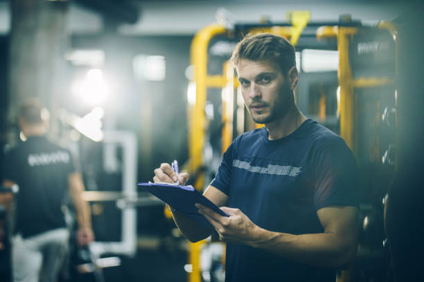 istock Serious fitness instructor writing a training plan in a gym. 864192898