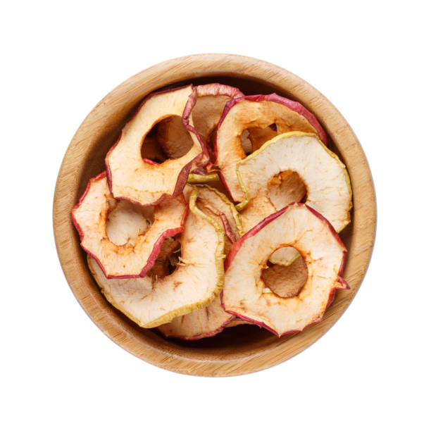 bol en bois avec chips de pomme maison isolé sur blanc. fruits secs. collation santé. vue de dessus. - dried apple photos et images de collection