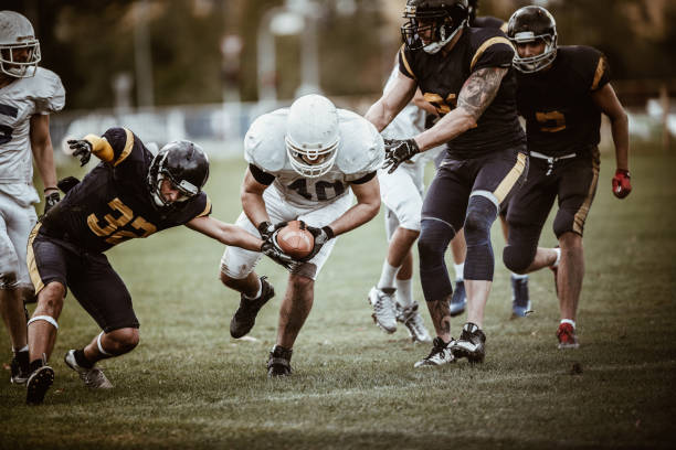 istock Determined American football player passing through defense for a touchdown. 864209870