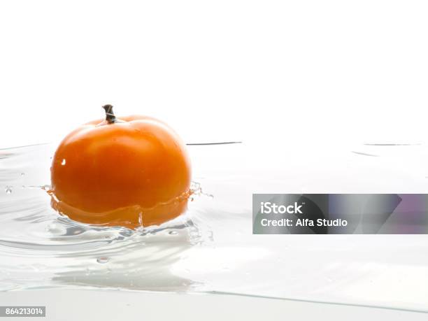 Yellow Tomato Fall In Water Photo In Action Drops Of Water Isolated White Background Stock Photo - Download Image Now