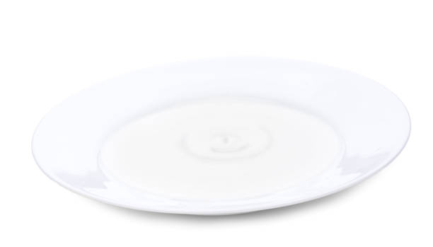 istock Milk splash and wave from milk drop at the white plate. Isolated over white background 864246868