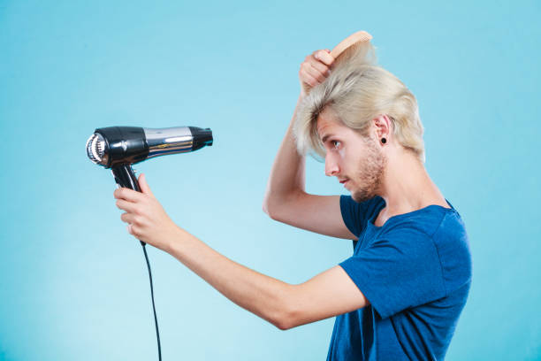 istock Trendy man with hair dryer 864255438