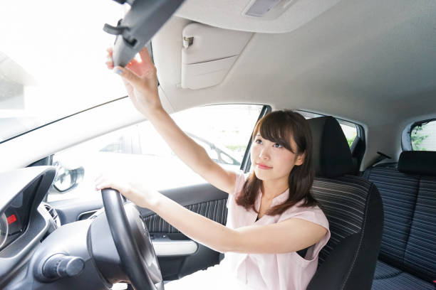 istock Woman in car checking mirror 864259616