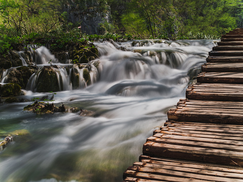 long exposure of waterfalls next to the wooden bridge