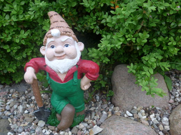 istock Funny Garden Gnome during gardening 864273526