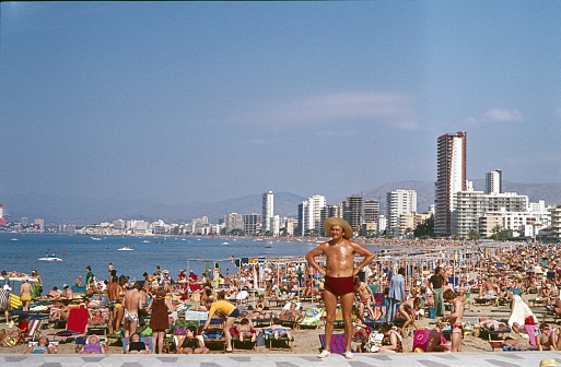 Las Canteras beach, Las Palmas de Gran Canaria, Gran Canaria, Spain, 1977. The tourist beach of Las Canteras in Las Palmas de Gran Canaria. In the seventies, the Canary Islands were one of the most relaxed holiday destinations for many Northern Europeans. Thousands moved to the beaches of southern Europe for sunbathing. All hotels on the island were booked up during the high season. The photo shows the first peak of mass tourism in the European area.