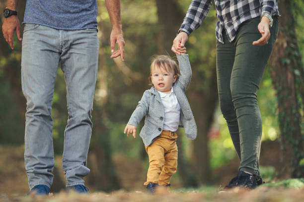 bambino che impara a camminare - baby first steps autumn child foto e immagini stock