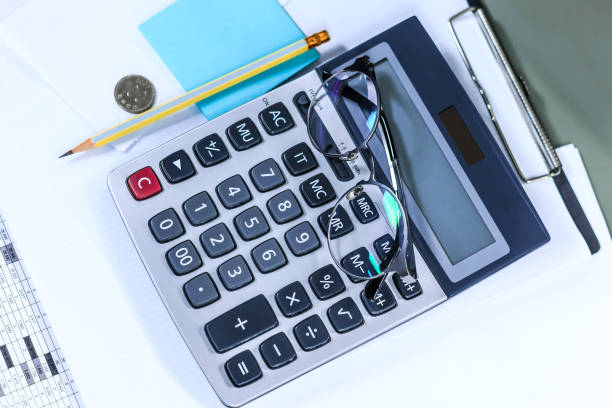 istock Calculator with pencil and glasses with notes 864294930