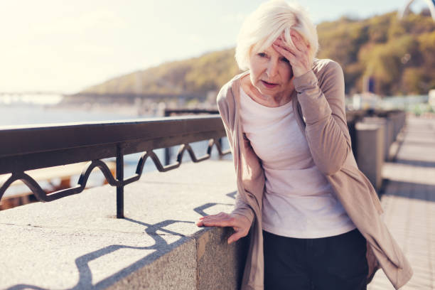 istock Elderly woman suffering from migraine on bridge 864307662