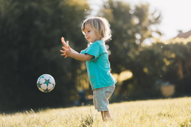 istock adorable young boy is playing with ball 864309210