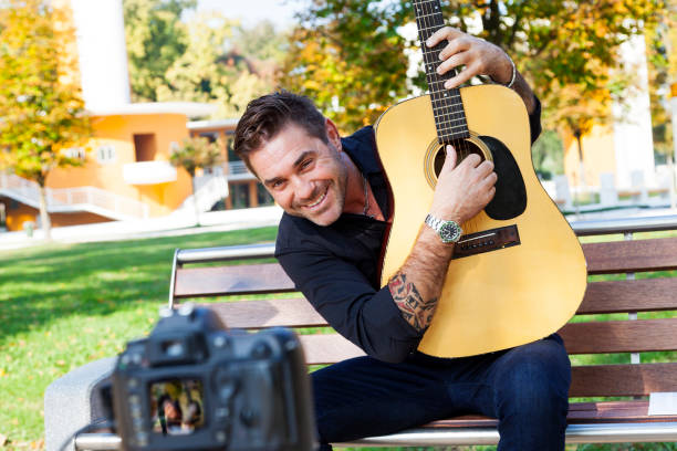 istock young man guitar teacher making a videos 864312416
