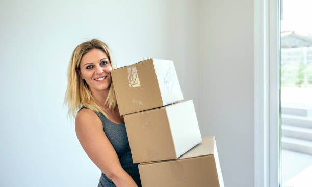 istock Woman carrying moving boxes 864312436