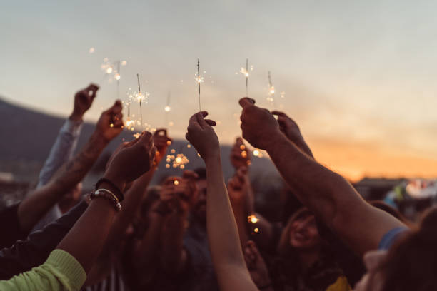 amigos celebrando año nuevo en la azotea - sparkler fotografías e imágenes de stock