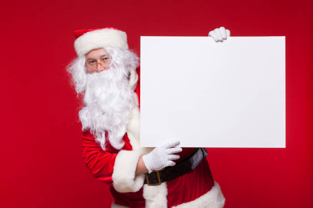 istock Santa Claus pointing in blank advertisement banner isolated on red background with copy space 864316112