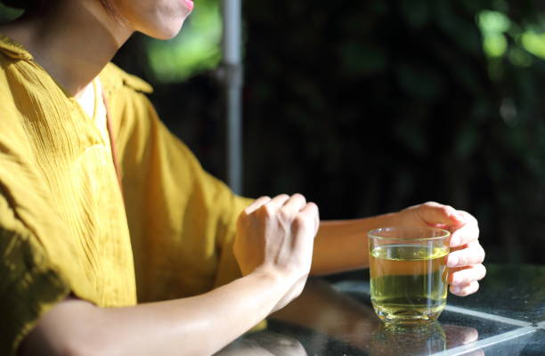 istock Young woman drinking green tea 864316804