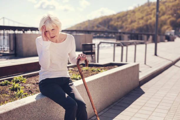 istock Tired senior lady pressing hand to a sore head 864316818