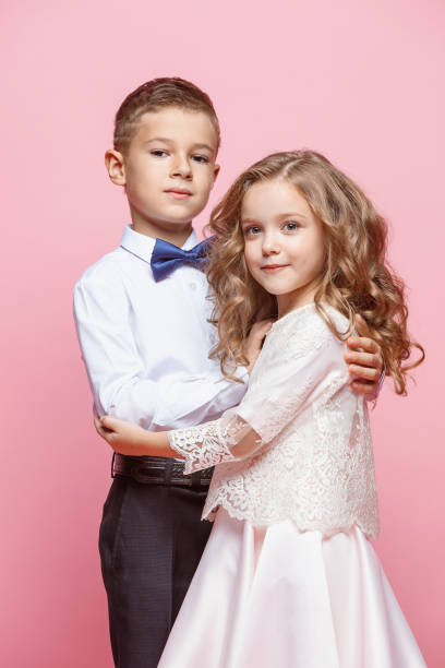 istock Boy and girl standing in studio on pink background 864318270