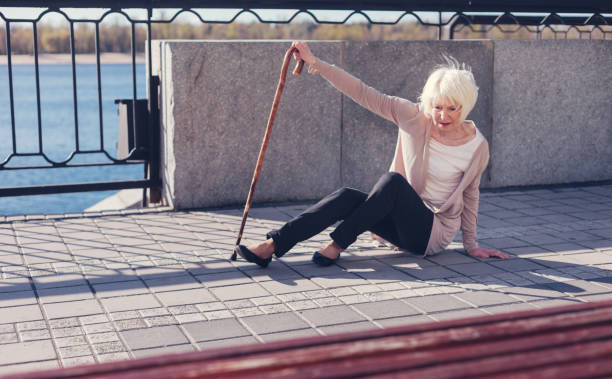 istock Thin elderly woman trying to get up from the pavement 864319262