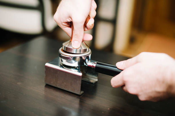 istock man using a tamper to press freshly ground coffee into a tablet 864320080