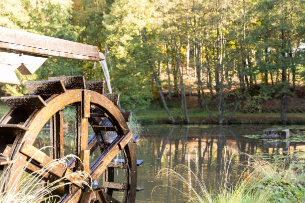istock old vintage wheel water mill moving water splashes into pond 864324372