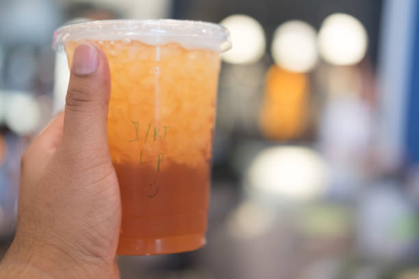 istock Young man holding Ice lemon tea in plastic glass with write name in glass 864324380