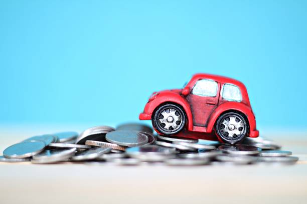 istock Miniature car model and coins on desk table 864337936