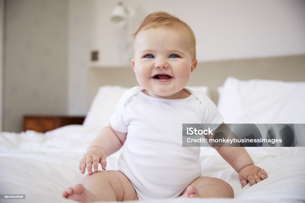 Happy Baby Boy Sitting On Parents Bed Baby - Human Age Stock Photo
