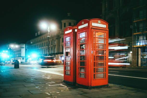 istock Red pay phone booth in London at night 864342080