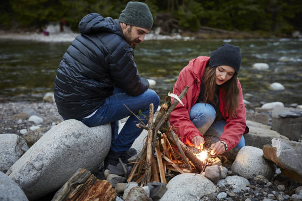 istock Young couple making a bonfire. Mountainous landscape 864342284